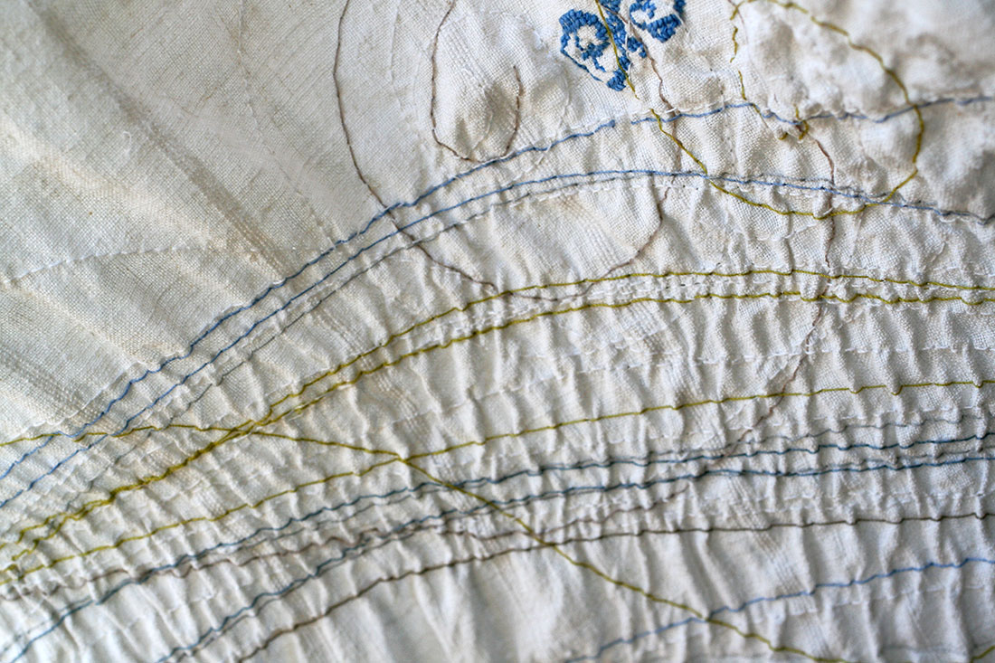 Ricamo astratto con fili colorati intrecciati su tessuto naturale