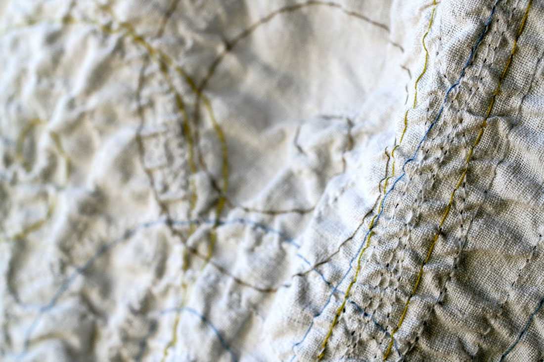 Primo piano di fili ricamati a spirale, a rappresentare il vento